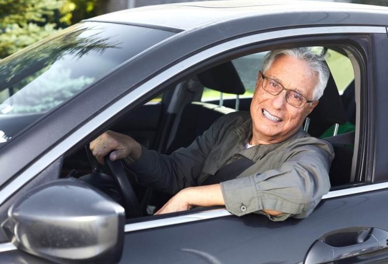 Senior driver smiling for having affordable vehicle coverage - Cheap car insurance