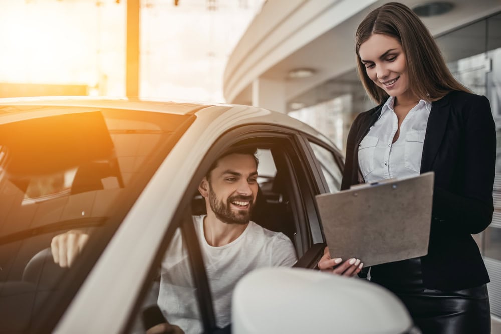 Insurance agent explaining full coverage benefits to driver in car
