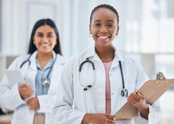 Two female doctors smiling - Cost-U-Less - cheap auto insurance in California