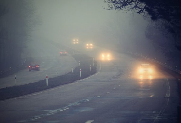 Cars drive through winter fog - cheap car insurance in California.